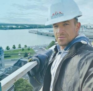 Inspecteur certifié d'Inspection Toiture Plus sur le toit d'un édifice à Montréal avec vue sur le fleuve Saint-Laurent en arrière-plan